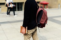 Young student man holding book and walking in university