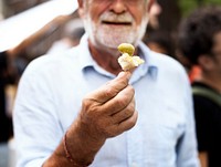 Senior Adult Man Showing Bread with Preserve Olive Sample Test