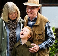 Senio rcouple with little boy gardening at home backyard