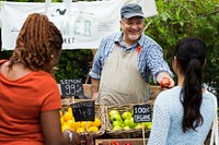 Greengrocer selling organic fresh agricultural product at farmer market