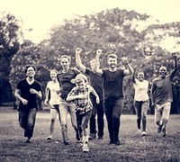 Group of people walking and running playful in the park