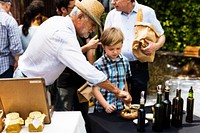 Little Boy Testing Preserve Olive Sample at Market