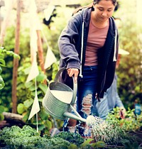 Woman watering organic fresh agricultural product