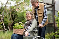 Man with her wife in a wheelchair out in the garden