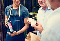 Man Offering Red Wine to Senior Men Food Stall