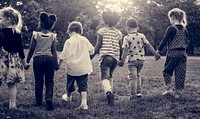 Group of kindergarten kids friends holding hands playing at park