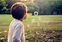 Kid with bubbles in a park
