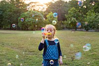 Little girl blowing bubble in the park