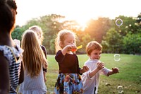Group of children blowing bubble in the park