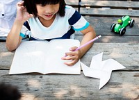 Little Asian Boy Drawing on Notebook