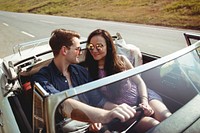 Couple Driving a Car Traveling on Road Trip Together