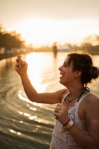 Caucasian woman taking photo sunset