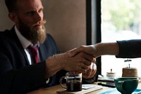 Business agreement handshake at coffee shop