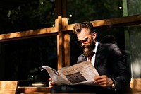 Businessman reading newspaper at coffee shop