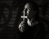 Woman holding cross praying for god religion grayscale