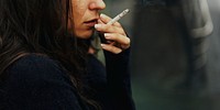 Woman smoking cigarette alone