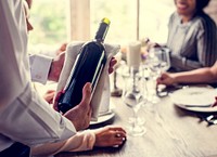 Waiter serving wine to the customers