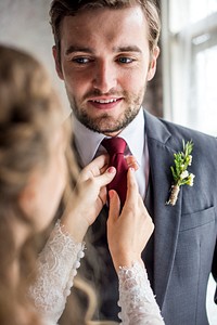 The bride take care of groom tie for wedding