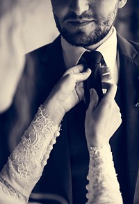 Bride Helping Groom Dressing Up for Wedding Ceremony