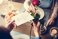 Proposing with a red rose at the dinner table
