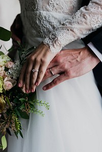Newlyweds&#39; hands wearing their wedding rings
