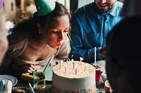 Woman Blowing Candles on Cake on Her Birthday Party Celebration
