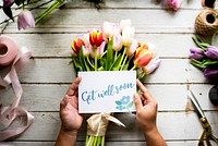 Hand Holding Show Get Well Soon Card with Tuips Flowers Background