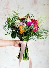 Hand holding beautiful bouquet of flowers