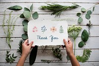 Hand Holding Show Thank You Card with Green Leaves Background