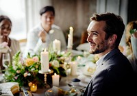 Groom listening to a speech at a wedding reception table