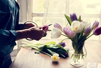 Florist woman decorates the flower on wooden table