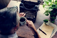 Man drinking coffee with vintage typewriter