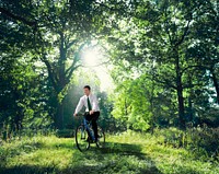 Businessman biking through a forest