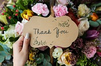 People Hand Holding Thank You Card with Flowers Bouquet Background