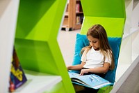 Girl reading book in school library