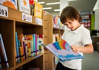 Boy reading  book at a school library