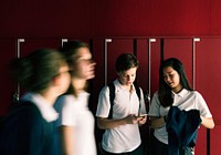 Students using a mobile phone in the hallway