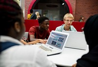 Group of diverse high school students using laptop