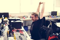Man stretching arms during break time at office