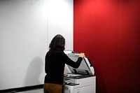 Woman using machine to copy document