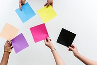 Diverse hands holding colourful square paper 