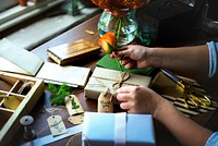 Hands diy wrapping gift box on wooden table