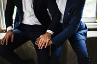 Closeup of Gay Couple Holding Hands Sitting Together