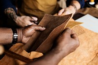 Closeup of craftsman holding leather handicraft