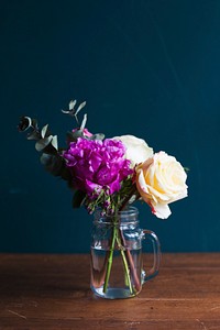 Fresh flowers arrangement in a vase on wooden table