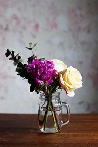Fresh flowers arrangement in a vase on wooden table