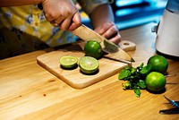 Hands cutting lime on a chopping board