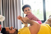 Dad playing with little daughter in bedroom