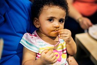 Little girl eating food with hands messy
