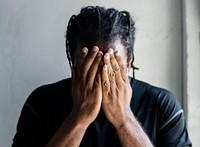 Black man with hands covered his face 